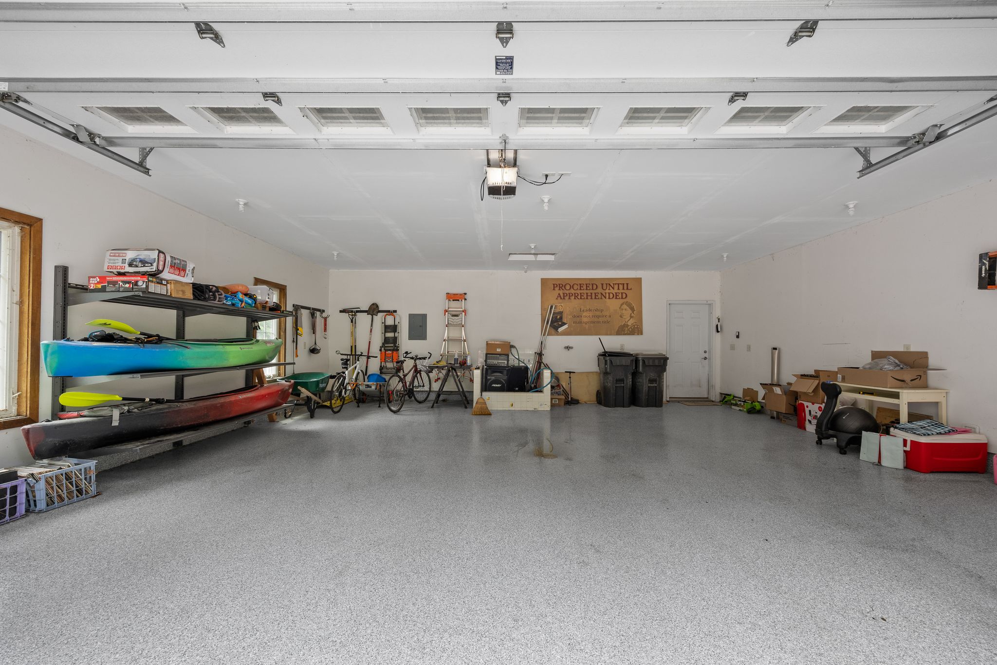 Interior of the two-car garage with kayaks, bicycles, and storage